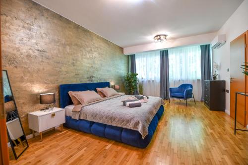 瓦拉日丁BNF Lounge的一间卧室配有一张大床和蓝色床头板