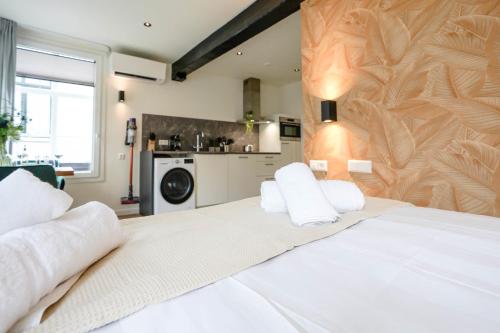 代尔夫特Deluxe 20m2 Canal View的一间带白色大床的卧室和一间厨房