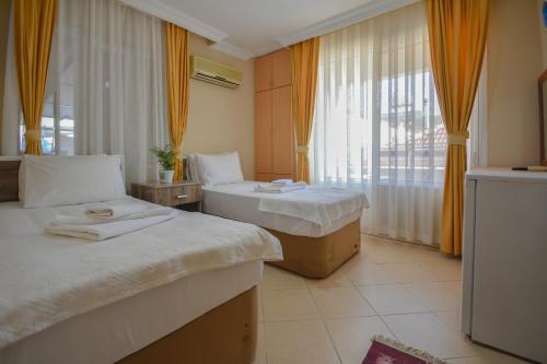 达特恰Huzur Royal Hotel的酒店客房设有两张床和窗户。