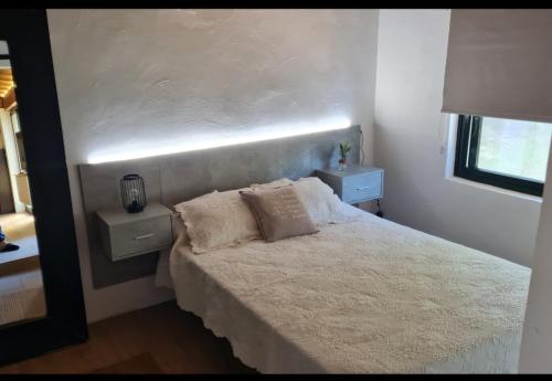 蓬特亚雷亚斯Casita Sarabia的一间卧室配有白色床和2个床头柜