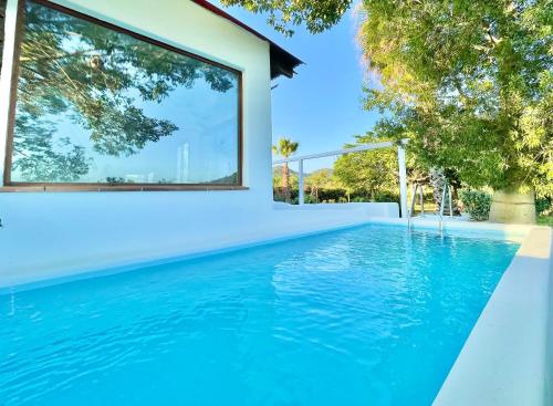 布拉内斯Villa Only Adults 2 Pax · Piscina Privada · A/C · WIFI · BBQ的一座房子前面的蓝色海水游泳池