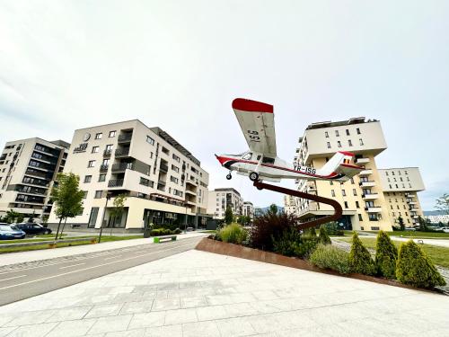 布拉索夫Kasper Coresi Mall - Rise Private Apartments & Suites的飞机在建筑物前的轨道上的模型