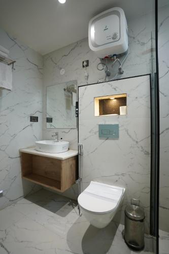 丹巴德HOTEL THE VENUE的白色的浴室设有卫生间和水槽。