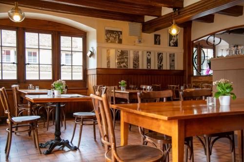 沃韦德拉广场酒店的餐厅设有木桌、椅子和窗户。