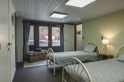 比尔曾Vakantiewoning & Fietslogies V E L O, Tussen Hasselt en Maastricht的一间卧室设有两张床和窗户。