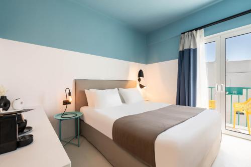 帕罗斯岛Play Paros的一间卧室设有一张床和一个大窗户