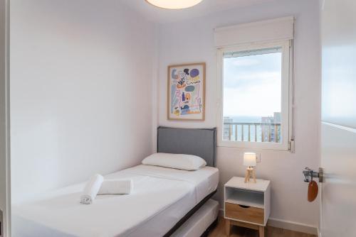 阿勒纳勒斯德尔索尔Myflats Premium Beach Front的一间白色的小卧室,配有床和窗户