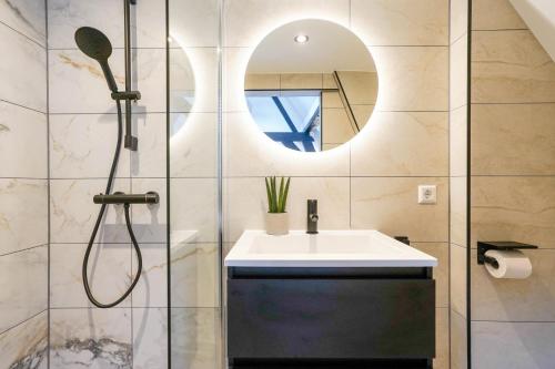 代尔夫特Romantic 35m2 City Center Suite的带淋浴、盥洗盆和镜子的浴室