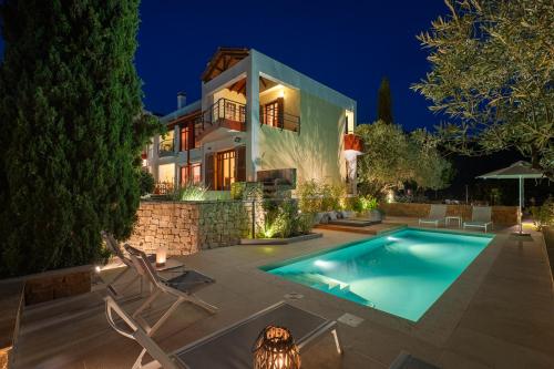 沃尔沃罗Avista Villa的夜间带游泳池的别墅