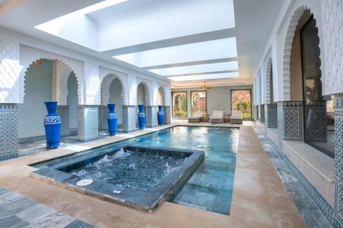 马拉喀什Janat Al Atlas Resort & Spa的一座蓝色花瓶建筑中的室内游泳池
