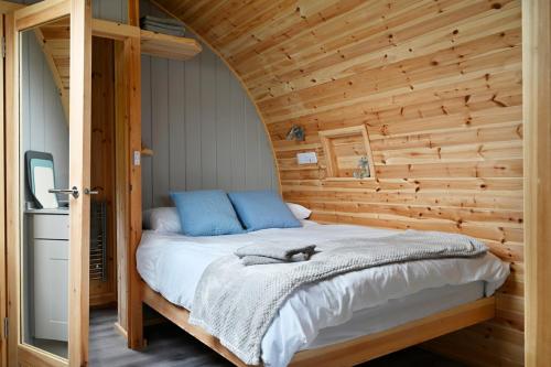 汤布里奇Little Quarry Glamping Bed and Breakfast的卧室配有木墙内的一张床