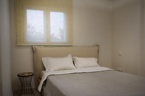 希俄斯SeaView Apartment Megas Limnionas的一间卧室配有带两个枕头的床和窗户