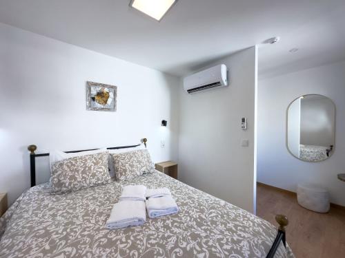 奥利维拉多霍斯比托Casa das Flores的一间卧室配有一张床,上面有两条毛巾