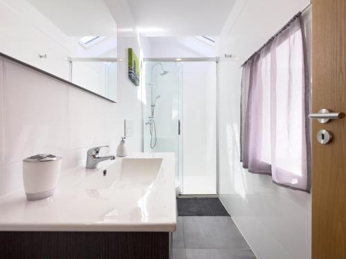 奥利维拉多霍斯比托Casa das Flores的白色的浴室设有水槽和淋浴。