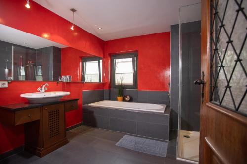 菲根Chalet Rosenweg的红色的浴室设有浴缸和水槽