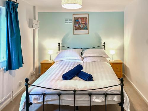 利普胡克Garden Cottage 2 - Uk42882的一间卧室配有一张带两个蓝色袜子的床