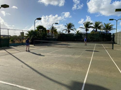 克拉伦代克Sand Dollar Bonaire的两人在网球场打网球