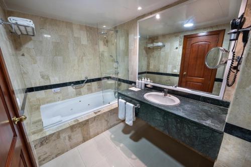 蓬塔卡纳Bahia Principe Grand Turquesa - All Inclusive的一间带水槽、浴缸和镜子的浴室