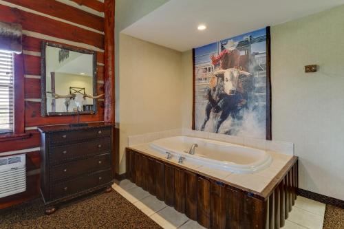 哥伦比亚Stoney Creek Hotel Columbia的带浴缸的浴室和一幅牛画