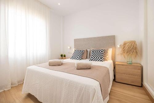 马罗APARTAMENTOS CARMEN的白色卧室配有一张带两个枕头的大床