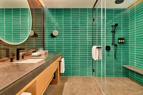 苏州苏州雅辰悦居酒店的浴室设有水槽和蓝色瓷砖淋浴。