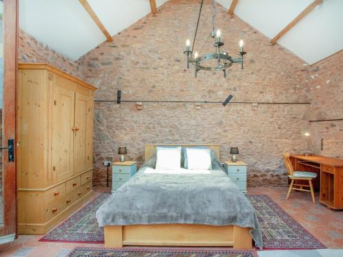SpaxtonParish Land Barn的卧室配有砖墙内的床铺