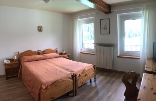 奥伦佐卡多利尤文图斯酒店的一间卧室设有木床和2个窗户。