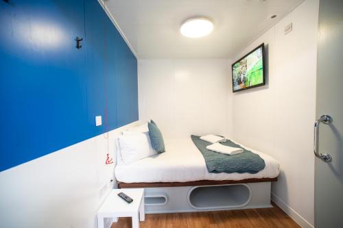 卢顿CiTi Hotel London Luton的小房间设有床铺和电视