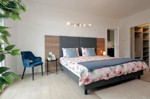 锡耶纳Siena Hills Apartments的一间卧室配有一张大床和一张蓝色椅子