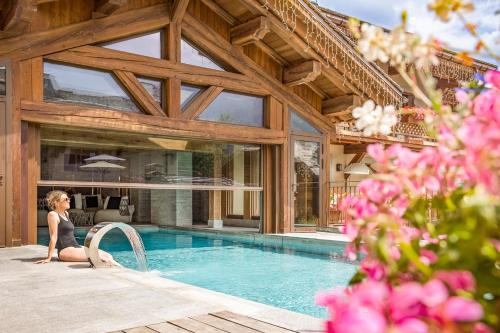 圣热尔韦莱班Armancette Hôtel, Chalets & Spa – The Leading Hotels of the World的坐在游泳池旁的女人