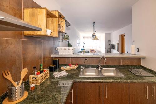拉达祖尔Primera línea de playa Radazul的厨房配有不锈钢盥洗盆和木柜