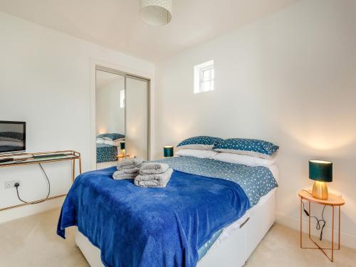 CroyOne The Loan的白色卧室配有蓝色的床和毛巾