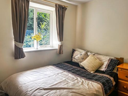 Cleobury MortimerWoodside Fishery - The Mallards的卧室内的一张床铺,带窗户