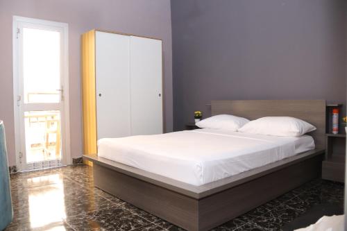 巴马科Appartement Bamako ACI 2000的一间卧室配有一张带白色床单的大床