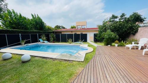 维拉卡洛斯帕兹Excelente Casa c/ Pileta Cerca del Centro的一个带游泳池和房子的后院