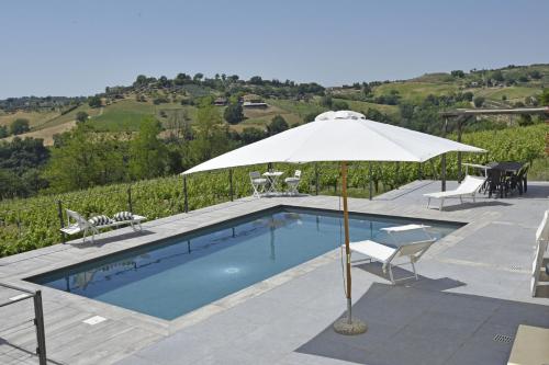 Montebuono卡萨莱伯爵夫人农庄酒店的一个带遮阳伞和桌椅的游泳池