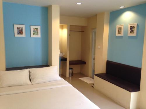 南邦C2公寓酒店的卧室配有白色的床和蓝色的墙壁