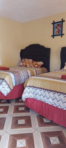 科万Hotel los reyes的两张床铺位于一间地板的房间