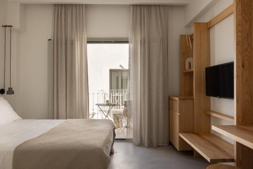 利瓦迪奥NŌSTOS Serifos的酒店客房,配有床和电视