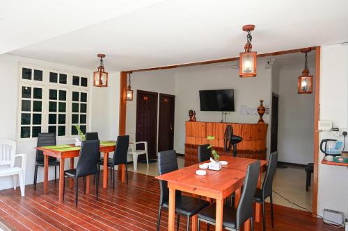 图鲁斯杜Thulusdhoo Inn的用餐室配有木桌和椅子