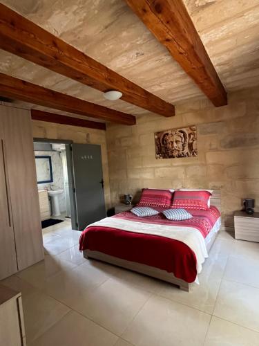 卢加The Cottage的一间卧室配有一张带红色枕头的大床