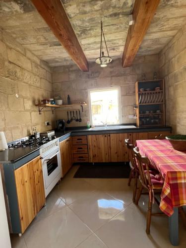 卢加The Cottage的厨房配有桌子和炉灶。 顶部烤箱