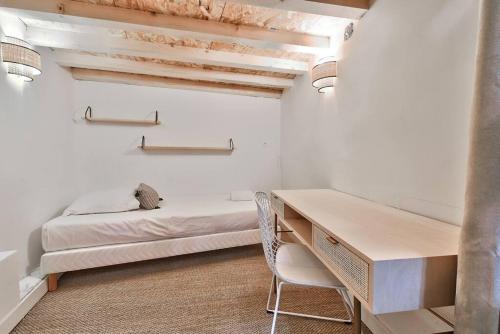 蒙彼利埃NOCNOC - Le Terrazzo - Petite piscine et jardin en ville的白色的客房配有书桌和床。