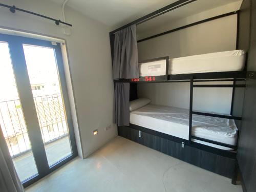 埃尔阿雷纳尔We Street Hostel - El Arenal-Albergue juvenil的一间卧室配有双层床和窗户。