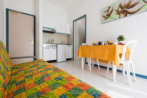 比比翁Aparthotel Pineda的客房设有厨房、桌子和椅子。