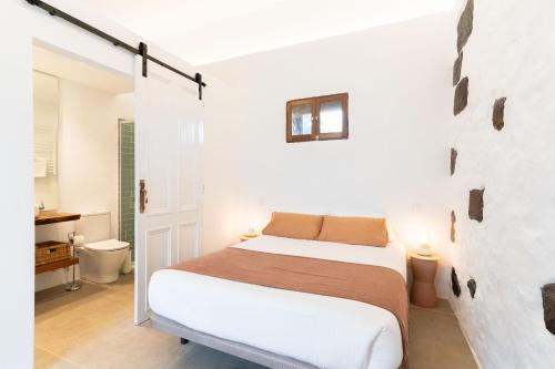 拉奥罗塔瓦Studio Canario with patio - Casa del Indiano的一间白色卧室,配有床和一间浴室