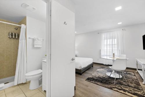 南迈阿密Sunset Inn-South Miami的白色的浴室设有卫生间和一张床