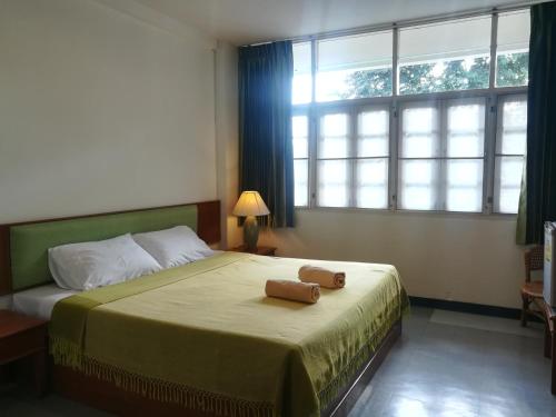 Ban Fang MinYMCA International Hotel Chiangrai的一间卧室设有一张床和一个大窗户