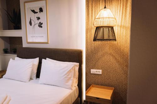 纳弗帕克托斯Vallia Suites-Green Luxury Suite A3的一间卧室配有一张床,旁边配有一盏灯