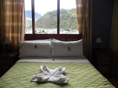 巴尼奥斯拉诺维恩托斯宾馆的一张带白色毛巾的床铺,配有窗户